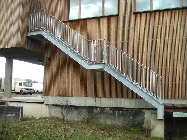 Stalen buitentrap langs een houten gevel